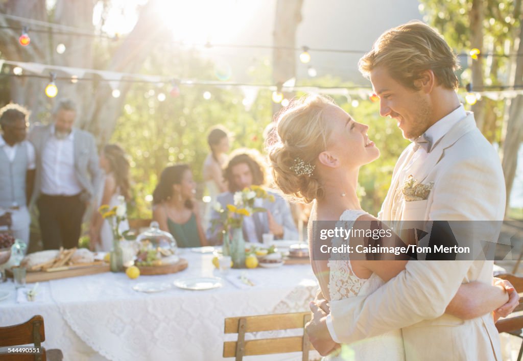 Young couple dancing during wedding reception in domestic garden