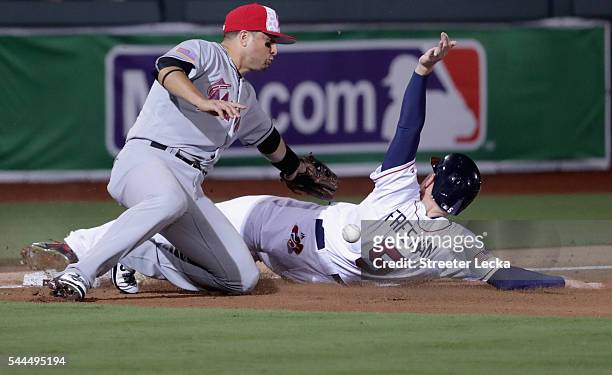 Martin Prado of the Miami Marlins misses a tag at third base on Freddie Freeman of the Atlanta Braves during their game at Fort Bragg Field on July...