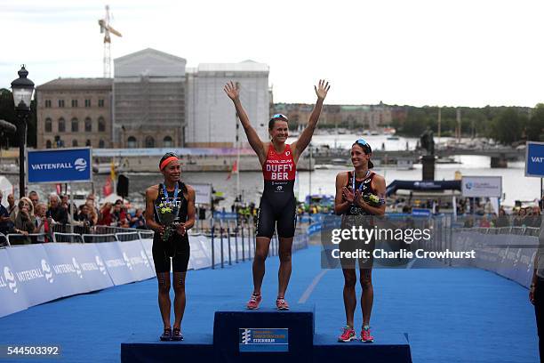 Andrea Hewitt of New Zealand second place, Flora Duffy of Bermuda in first and Helen Jenkins of Great Britain in third all celebrate their placings...