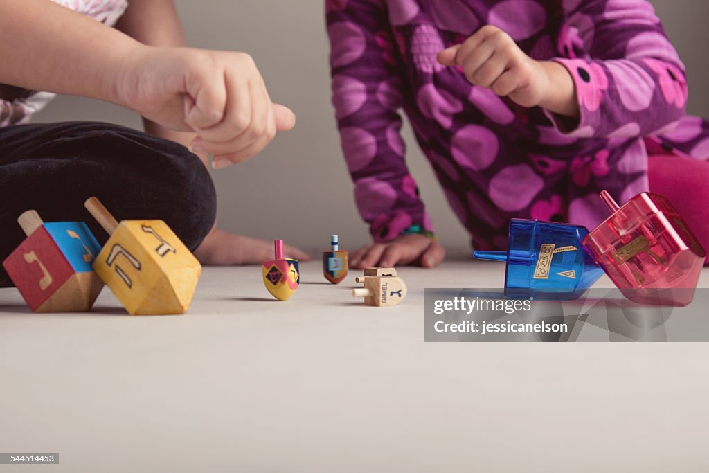 Two girls playing with dreidels to celebrate Hanukkah