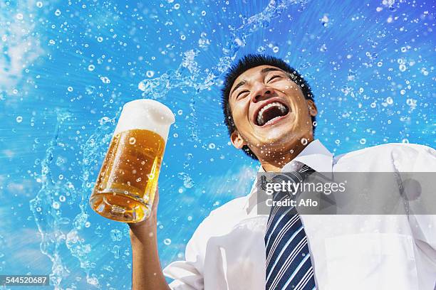 japanese businessman drinking draft beer - beer splash stock pictures, royalty-free photos & images