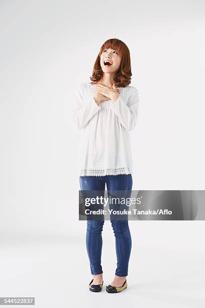 full length portrait of young japanese woman against white background - japanese woman looking up stock-fotos und bilder