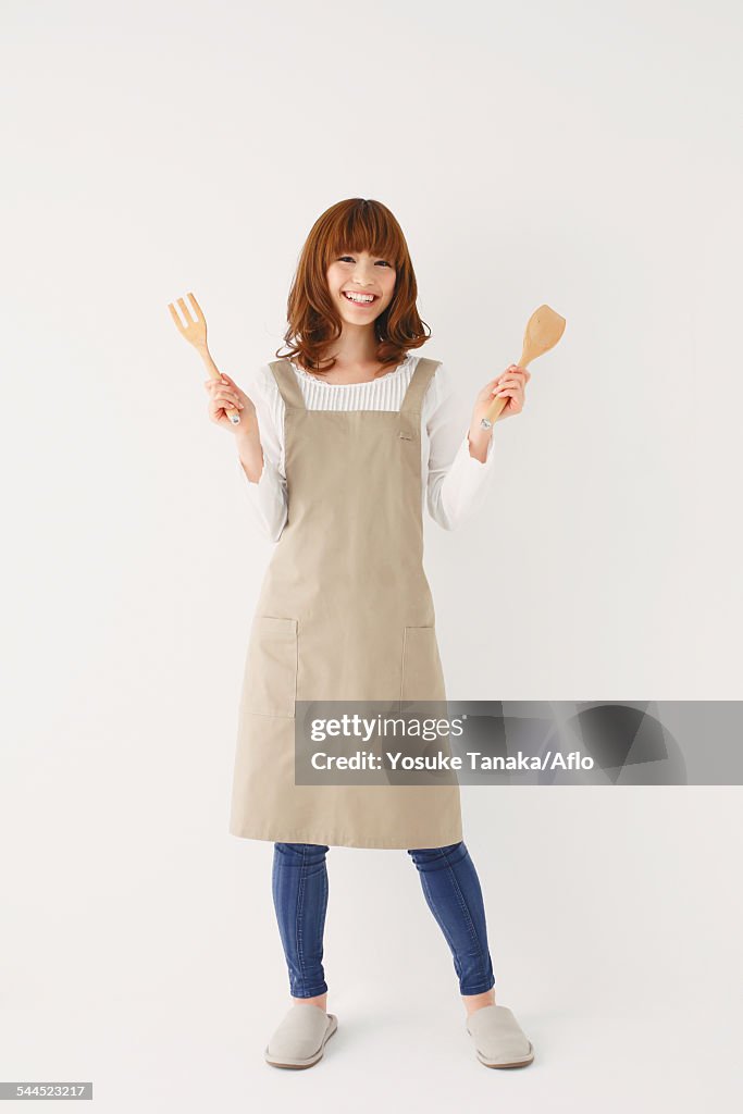 Full length portrait of young Japanese woman against white background