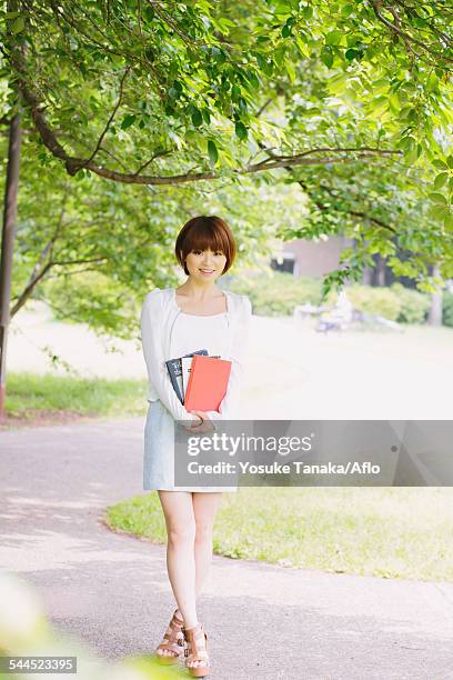 portrait of young japanese woman in a park - japanese short skirts stockfoto's en -beelden