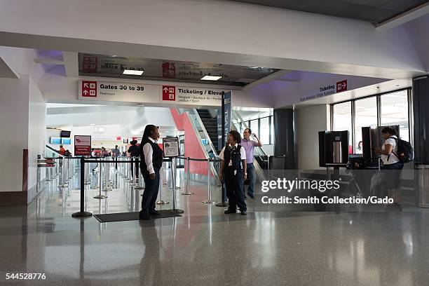 At Los Angeles International Airport, two security staff members converse while waiting for passengers to enter Tsa Pre-Check and priority security...