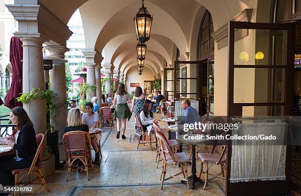 On the outdoor patio of Bar Bouchon, part of the Bouchon bistro-style restaurant owned by chef Thomas Keller, diners talk and enjoy their meals,...