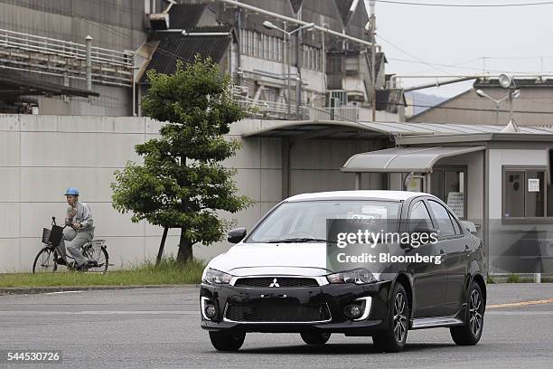 Worker drives a Mitsubishi Motors Corp. Vehicle near the company's Mizushima plant in Kurashiki, Okayama Prefecture, Japan, on Friday, June 17, 2016....