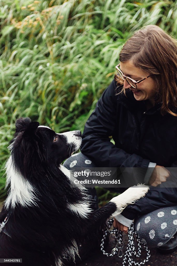 Smiling young woman communicating with her Border Collie