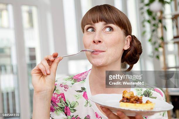smiling woman enjoying piece of cake - smaka bildbanksfoton och bilder