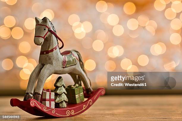christmas rocking horse in front of points of light - christmas toys wooden background stockfoto's en -beelden