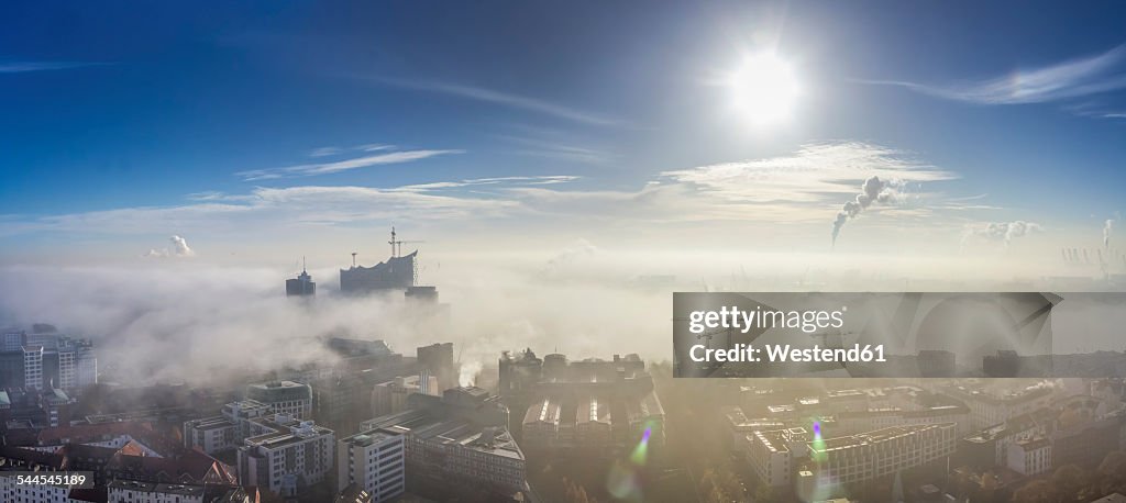 Germany, Hamburg, Elbphilharmonie and port sticking out of dense fog