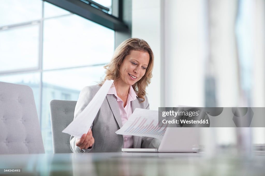 Businesswoman using laptop in conference room