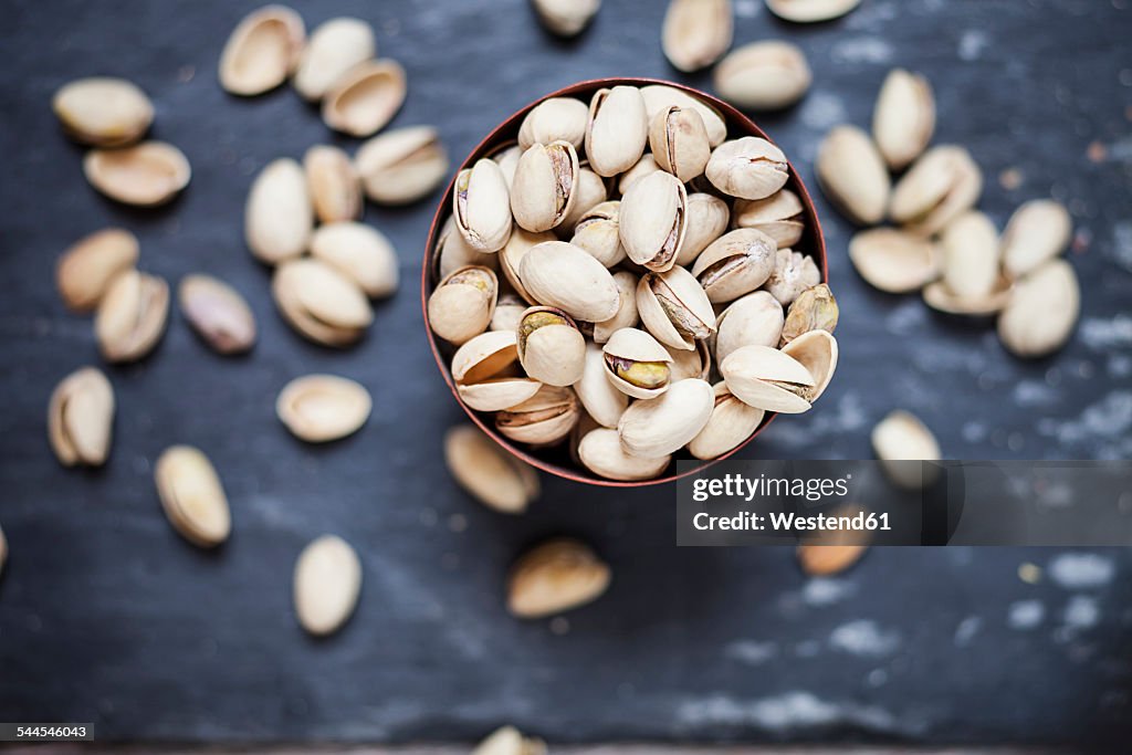 Bowl of roasted and salted pistachios on slate