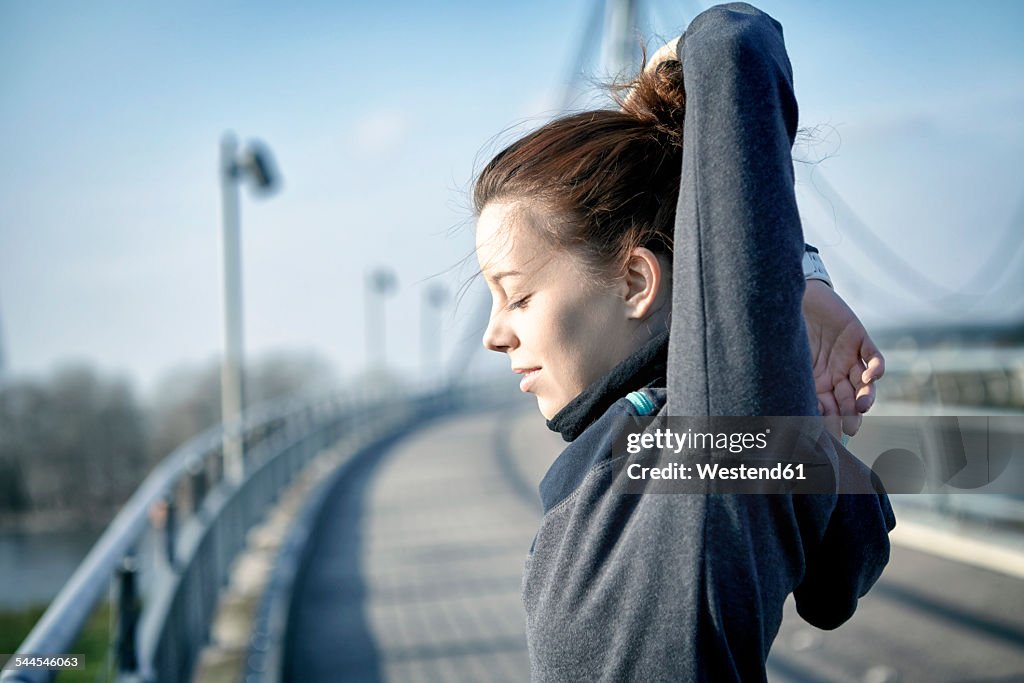 Young woman doing stretching exercise after jogging