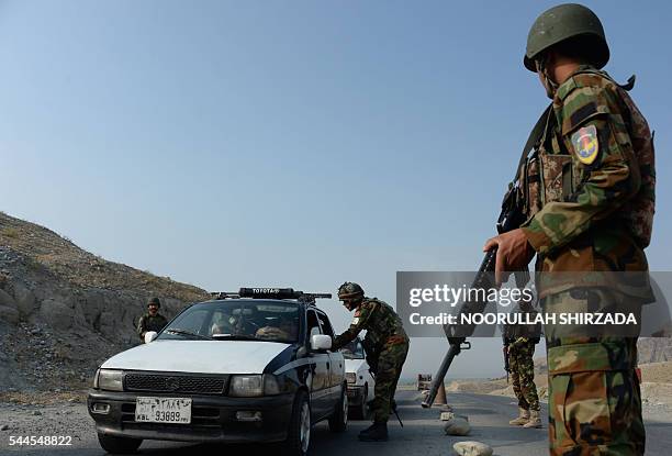 An Afghan National Army soldier searches a vehicle at a checkpoint ahead of forthcoming Eid Al-Fitr celebrations on the outskirts of Jalalabad on...