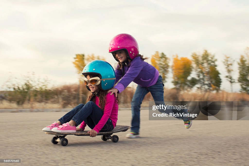 Two Young Girls Race on Skateboard