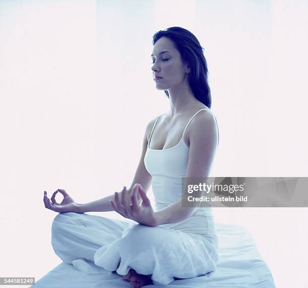 Frau beim Yoga, Meditation im halben Lotussitz, Hände im Chinmudra