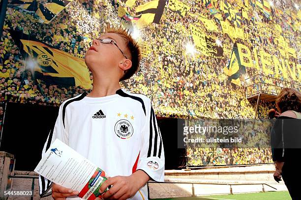 Deutschland, Nordrhein-Westfalen, Dortmund - junger Fussballfan im DFB-Trikot vor der Willkommenswand am Dortmunder Hauptbahnhof -