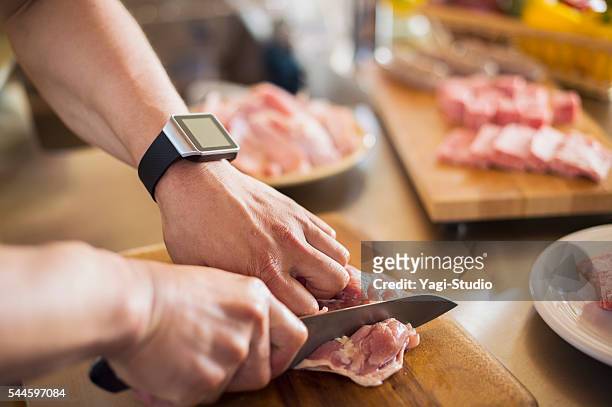 hombre adulto medio cortando el pollo con un cuchillo de cocina - red meat fotografías e imágenes de stock