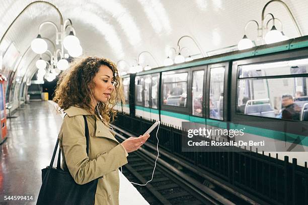 freundliche frau am telefon, u-bahn im hintergrund - subway paris stock-fotos und bilder