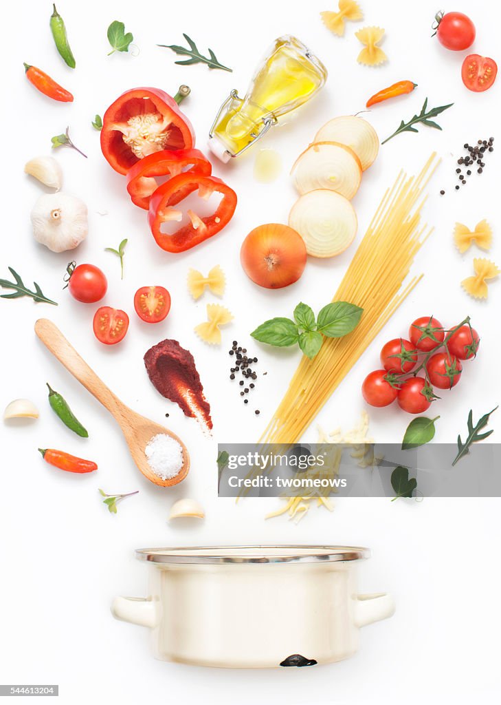 Minimalist style flat lay pasta recipe ingredients and cooking pot on white background.