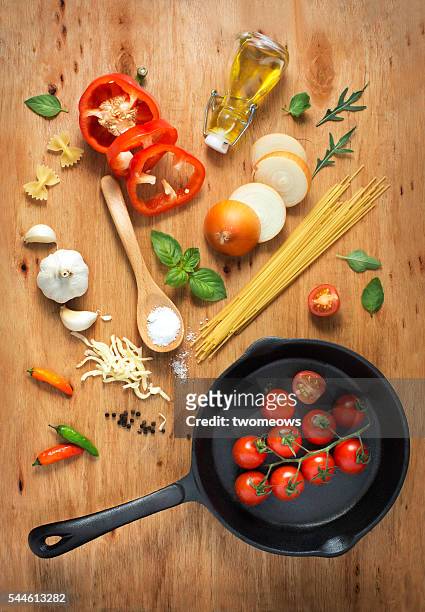 flat lay cooking pan with freshly cut paste recipe ingredient on rustic wooden table top. - dieta mediterranea foto e immagini stock