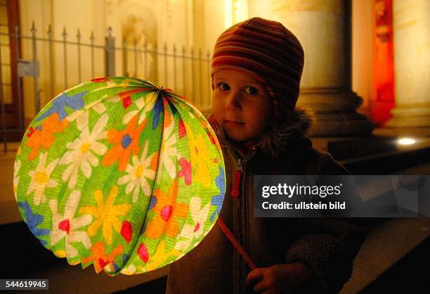 Little girl holding a paper lantern at a St. Martin's Day procession in Berlin, Germany, November 2006. Deutschland, Berlin: Laternenumzug zum...