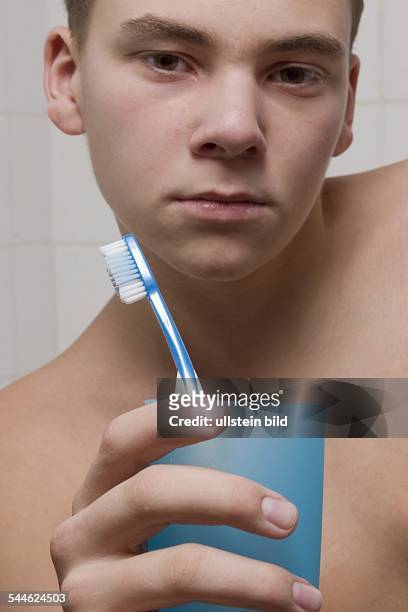 Zahnpflege, Junge mit Zahnbuerste und Zahnputzbecher