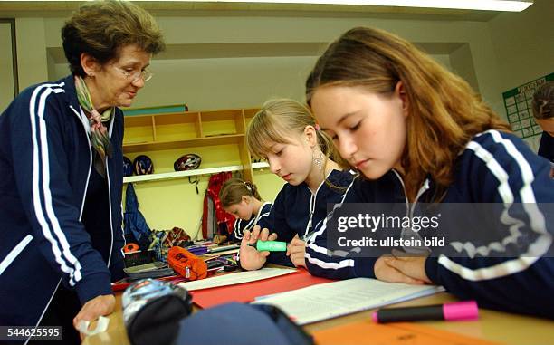 Deutschland; Berlin - Spandau; Mèdchen und Lehrerin in Schuluniform an der Linden Grundschule-