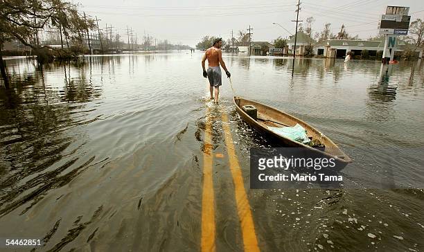 Man pulls a canoe down a flooded street in the hard-hit Chalmette community of Saint Bernard's Parish September 3, 2005 in New Orleans. Today was the...