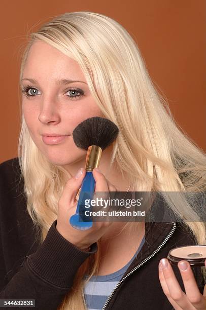 Kosmetik, junge Frau trägt Puder mit einem Pinsel auf