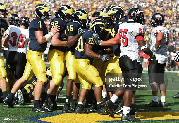 Teammates congratulate Mike Hart of Michigan after he rushed for a touchdown against Northern Illinois at Michigan Stadium on September 3, 2005 in...