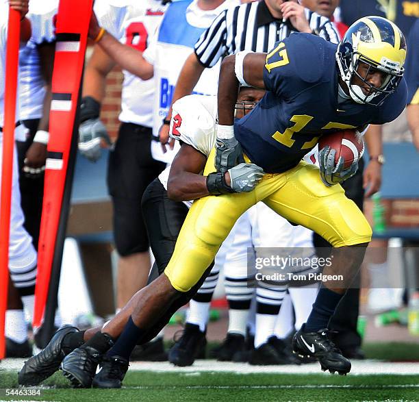 Carl Tabb of Michigan gains yards defended by Adriel Hansbro of Northern Illinois at Michigan Stadium on September 3, 2005 in Ann Arbor, Michigan....