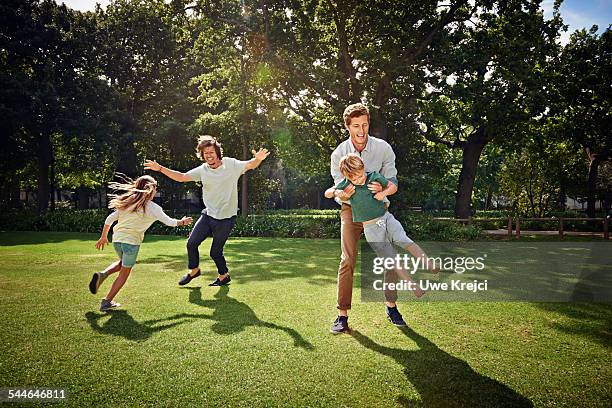 father and children playing in park - 2 year old blonde girl father stock pictures, royalty-free photos & images