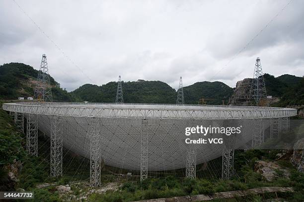 Workers lift the last panel to install into the center of a Five-hundred-meter Aperture Spherical Telescope on July 3 China. The dish-like telescope,...