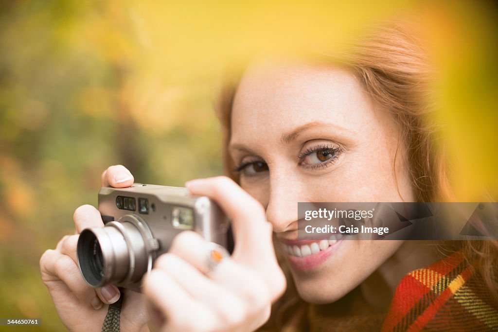 Woman taking photo in Autumn woodland