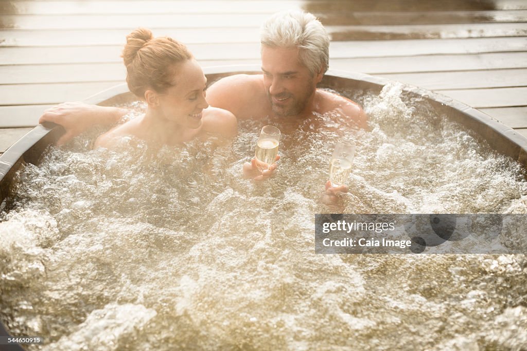 Couple drinking champagne in hot tub