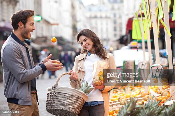 couple buying fruit at the market - oranges in basket at food market stock pictures, royalty-free photos & images