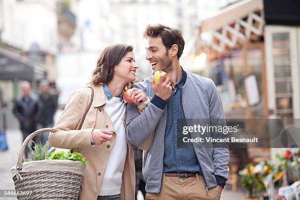 couple eating apple in the street - regarder une pomme photos et images de collection