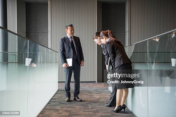 three japanese business people meeting in modern corridor - woman bowing stock pictures, royalty-free photos & images