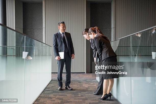 three japanese business people meeting in modern corridor - buga bildbanksfoton och bilder