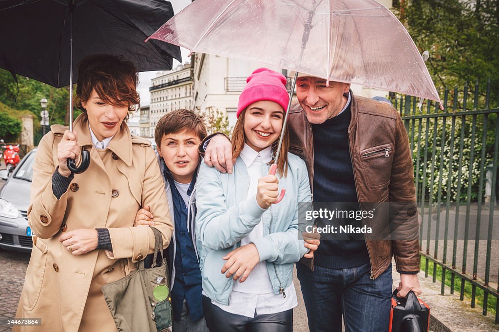 Happy french family out in the rain