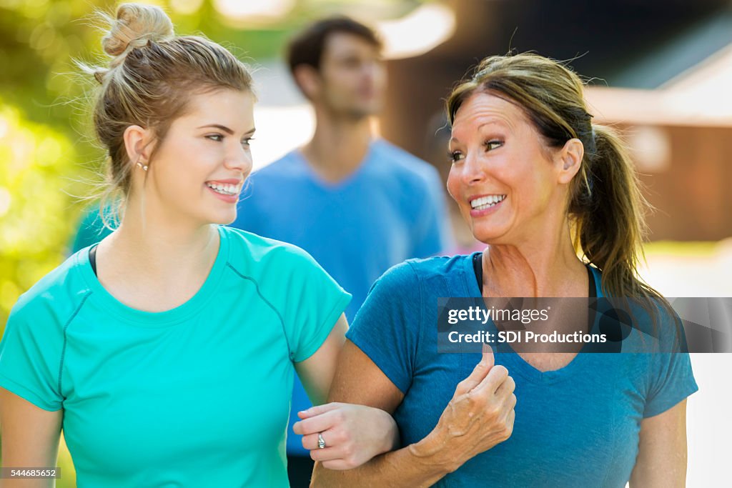 Senior sorridente mãe e sua filha a andar juntos