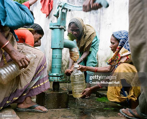 women pumping water from a well - falta fotografías e imágenes de stock