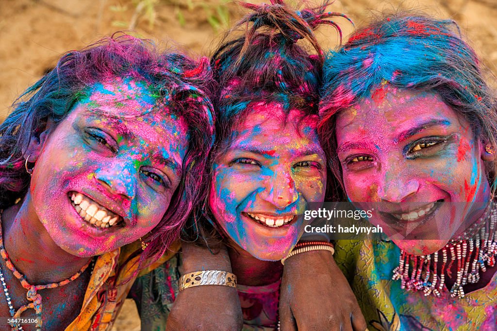 Group of happy Indian girls playing holi, desert village, India