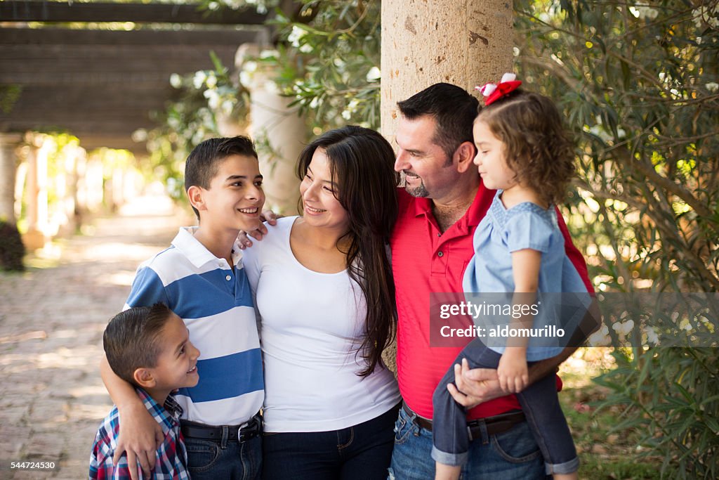 Latin family of five standing and smiling at each other