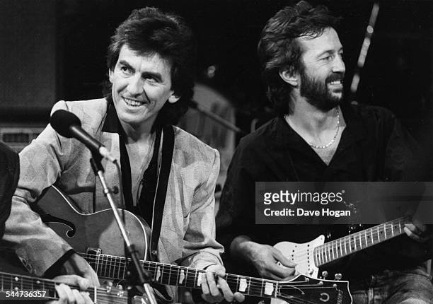 Musicians George Harrison and Eric Clapton performing on stage together as part of an all-star band for music legend Carl Perkins, October 23rd 1985.
