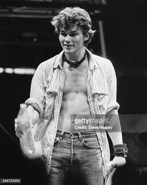 Musician Morten Harket, lead singer with pop band 'A-Ha', holding a water bottle as he performs on stage, December 9th 1986.