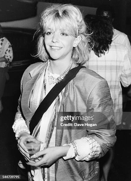 Actress and model Leslie Ash holding a drink at a party, circa 1988.