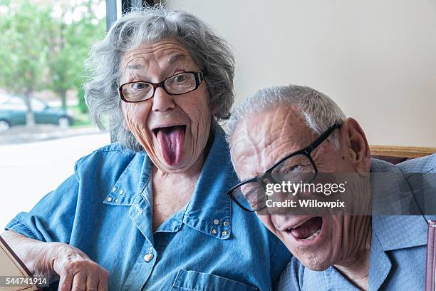 grandpa photo bombing grandma's funny tongue wagging face - funny fat women 個照片及圖片檔